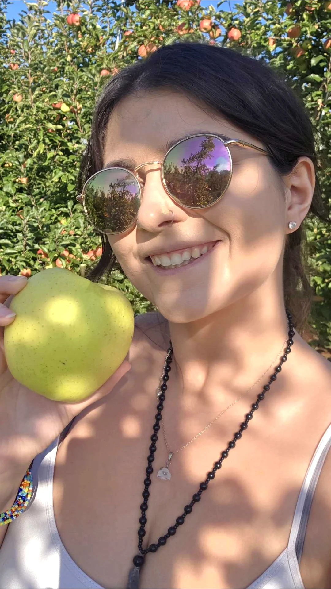 ToniMarie Iglesia holding an apple in an orchard